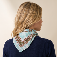 Foulard Sarita vu de dos : le drapé sur la nuque, damier vert d’eau et bordure fleurie