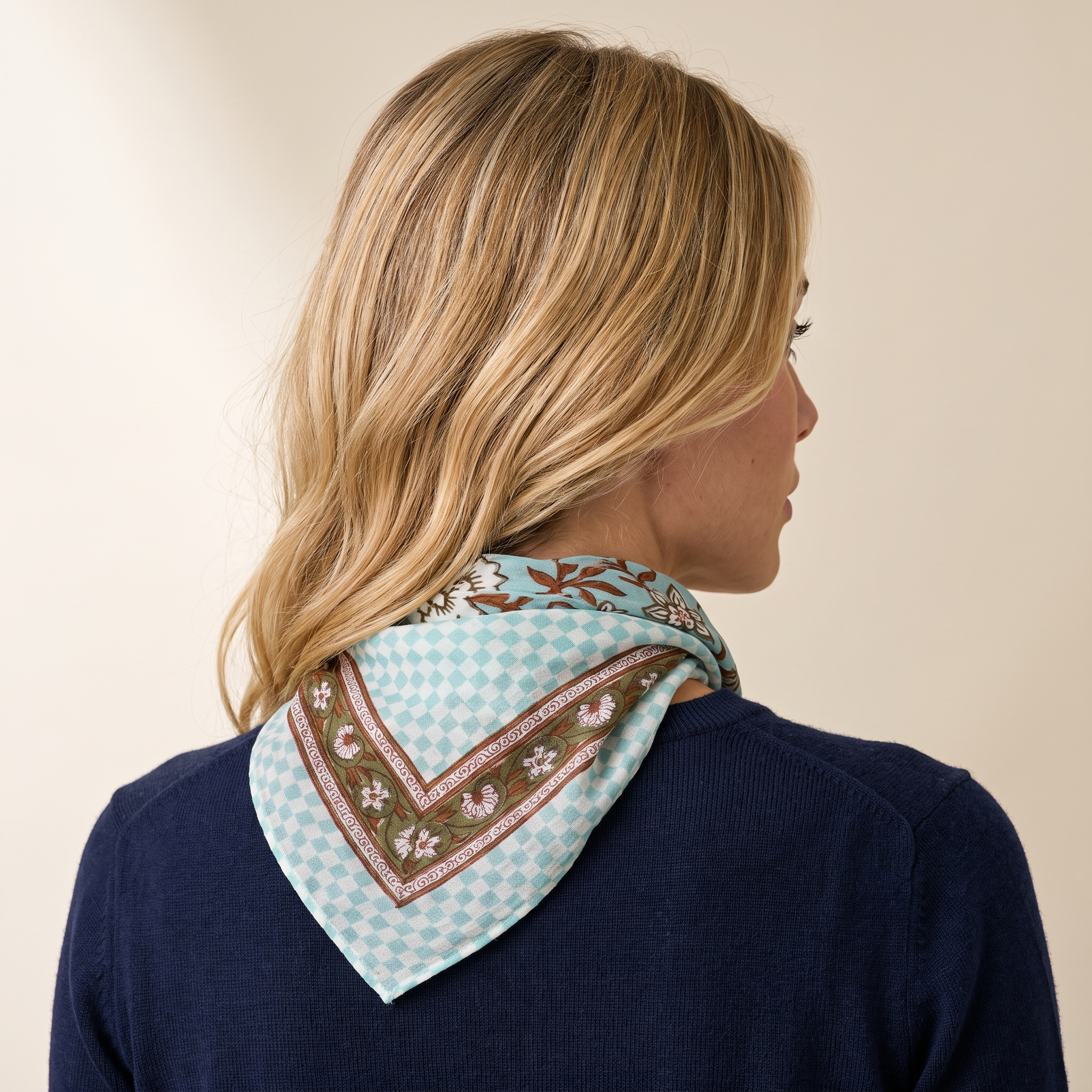 Foulard Sarita vu de dos : le drapé sur la nuque, damier vert d’eau et bordure fleurie