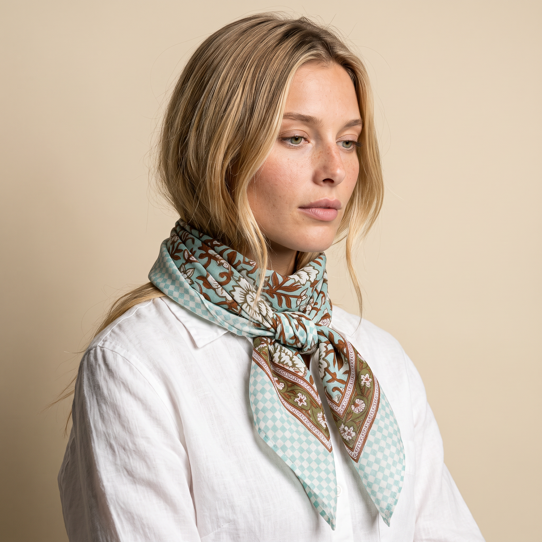Foulard Sarita noué au cou, porté de trois-quarts sur fond écru