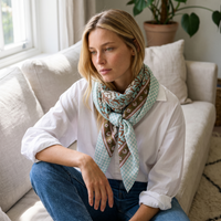 Foulard Sarita porté dans un intérieur, noué au cou sur une chemise blanche