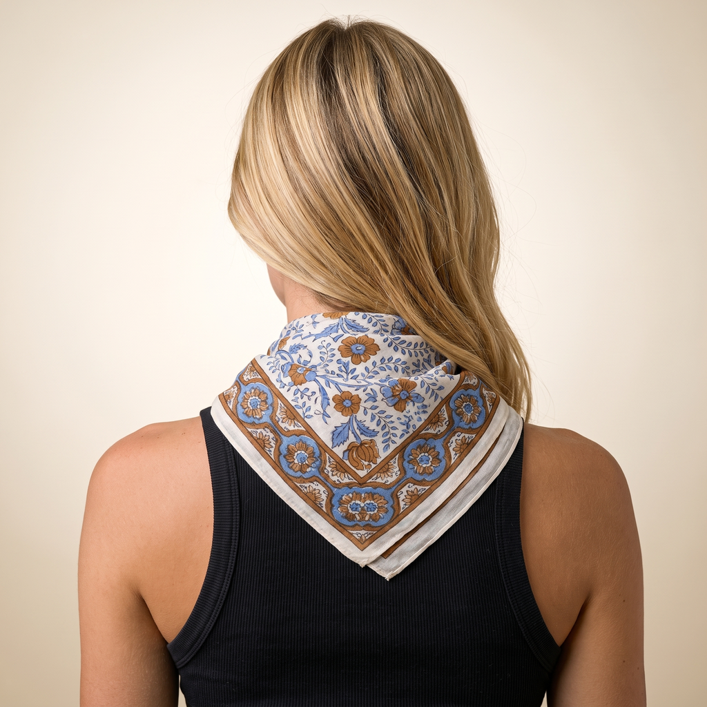 Foulard Nabha vu de dos : le drapé sur la nuque, fleurs bleues et bordure caramel