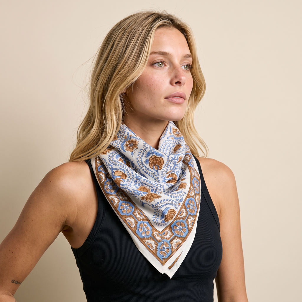 Foulard Nabha porté : noué au cou sur un débardeur noir, fleurs bleues sur fond crème