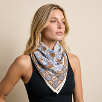 Foulard Nabha porté : noué au cou sur un débardeur noir, fleurs bleues sur fond crème