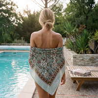 Foulard Sarita porté en étole sur les épaules nues, au bord d’une piscine