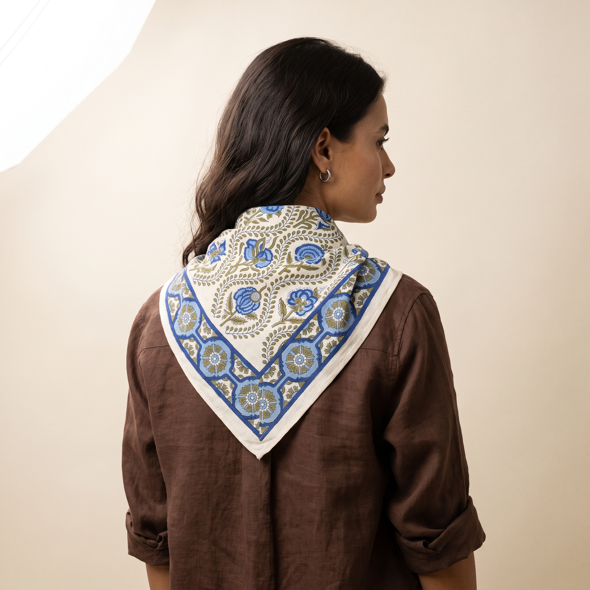 Foulard Chandni vu de dos : le drapé sur la nuque, lianes olive et bordure à médaillons bleus