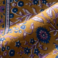 Détail du blockprint du foulard Sona : trame du coton, fleurs violettes et bleu roi sur ocre