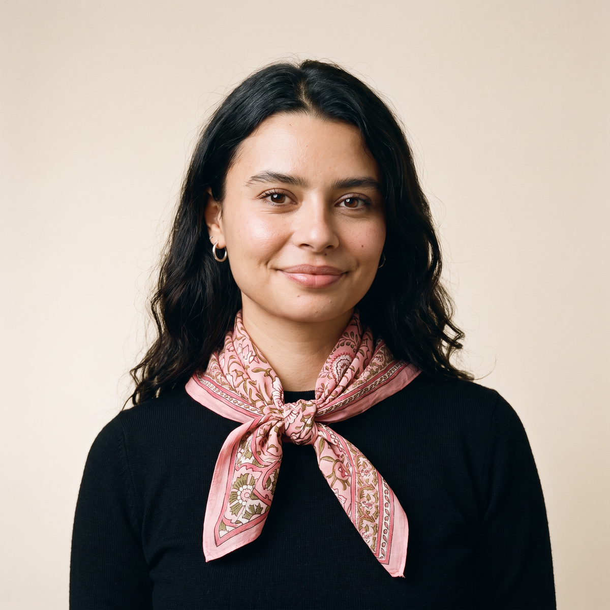 Foulard Lalima porté : noué au cou sur un pull noir, feuillage olive sur voile rose