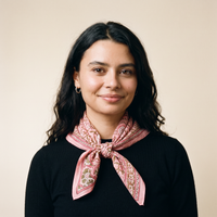 Foulard Lalima porté : noué au cou sur un pull noir, feuillage olive sur voile rose