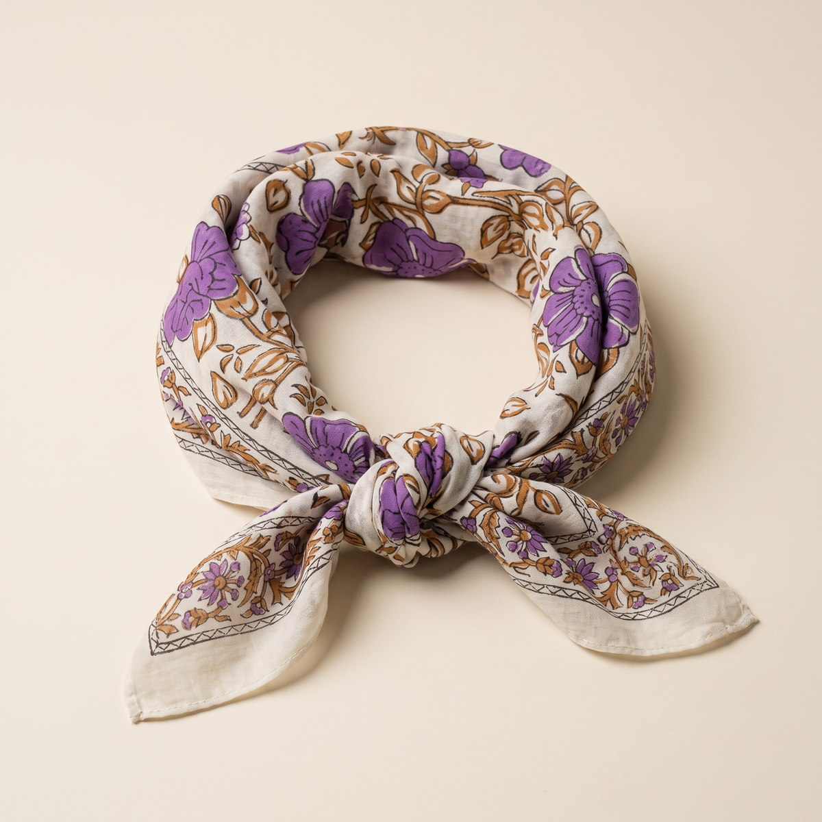 Foulard Sandhya noué en anneau : voile de coton écru, fleurs violettes et feuillage ocre imprimés au bloc