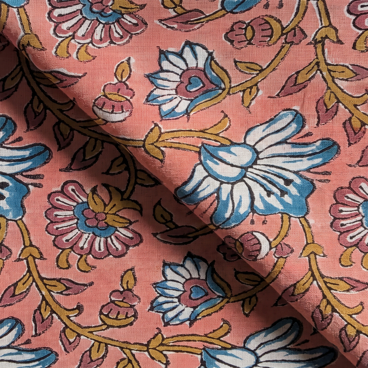 Détail du blockprint du petit foulard Usha : trame du voile de coton, fleurs bleu pétrole et volutes ocre sur rose corail