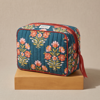 Trousse de toilette Ambar en coton matelassé blockprint bleu canard et corail, posée sur son socle