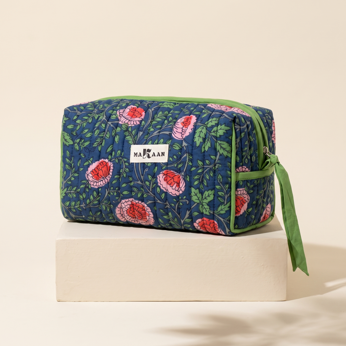 Trousse de toilette Jaya en coton matelassé blockprint bleu de nuit et vert, posée sur son socle