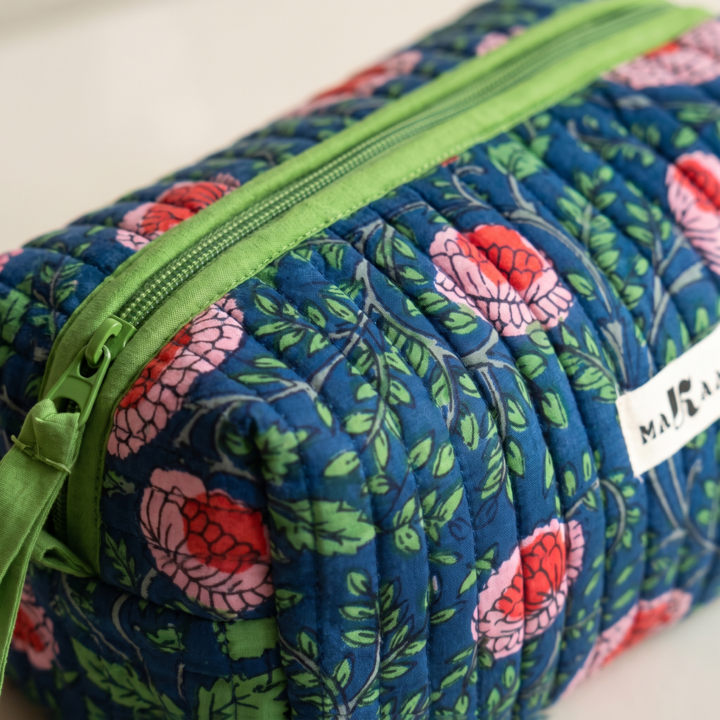 Détail de la trousse Jaya : matelassage vertical, zip et ruban de coton vert