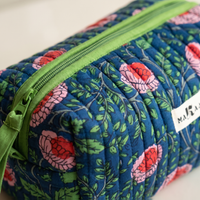 Détail de la trousse Jaya : matelassage vertical, zip et ruban de coton vert