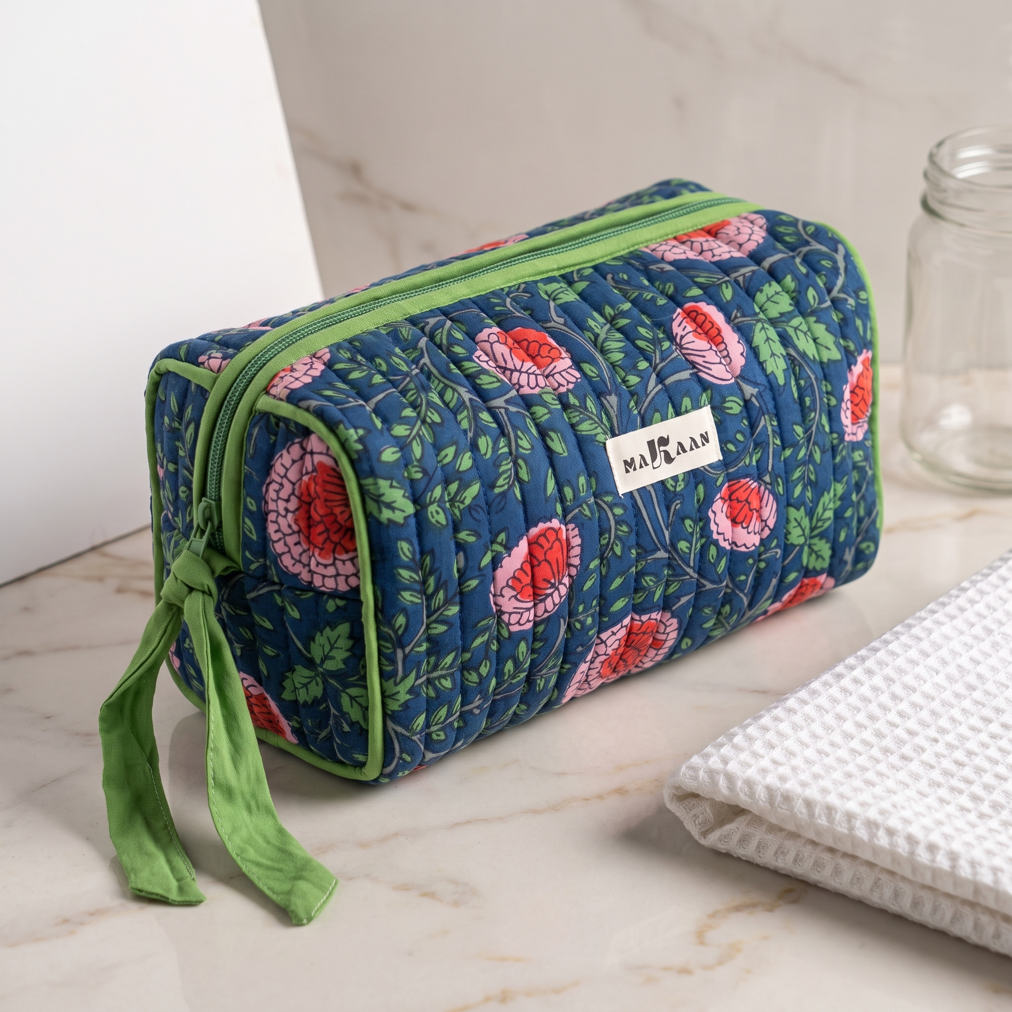 Trousse Jaya posée sur une vasque de marbre clair, ruban noué