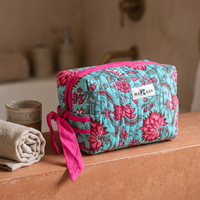 Trousse Padma posée sur une étagère de salle de bain en terre cuite, ruban noué