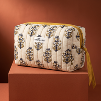 Trousse de toilette Roshni en coton matelassé blockprint crème, olive et marine, posée sur son socle