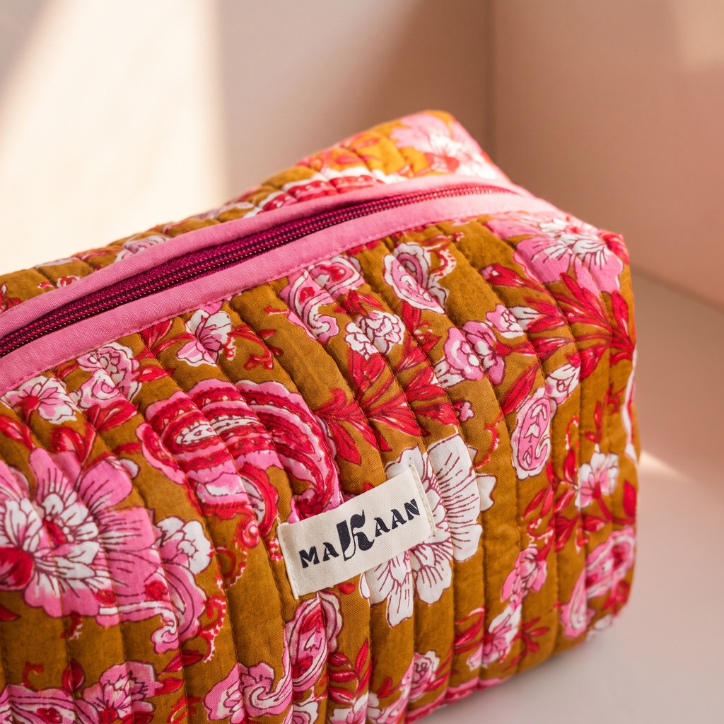 Détail de la trousse Anjali : matelassage vertical, zip et ruban de coton rose