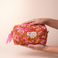 Trousse de toilette Anjali tenue à deux mains, sa taille réelle