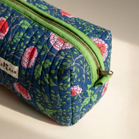 Détail de la trousse Jaya : matelassage vertical, zip et ruban de coton vert