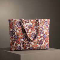 Cabas Gulzar en coton matelassé : grand sac blockprint à jardin prune et corail sur crème, deux anses en tissu imprimé, posé sur un socle