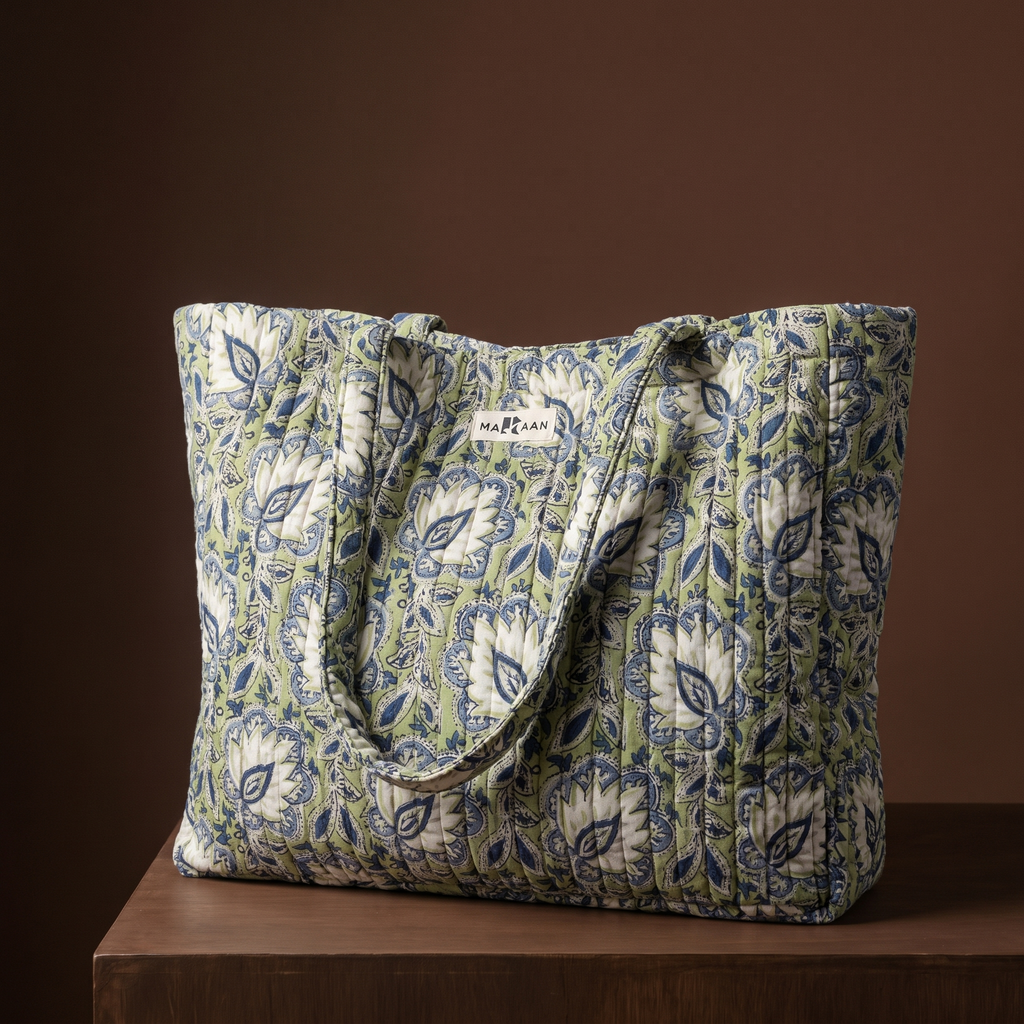 Cabas Sarasi en coton matelassé : grand sac blockprint à fleurs blanches et feuillage vert sur crème, deux anses en tissu imprimé, posé sur un socle