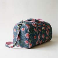 Sac week-end Kusum vu de bout : panneau latéral arrondi bordé de biais rose, anneau et boucle en laiton de la bandoulière