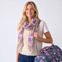Femme souriante portant le sac week-end Kusum à l’épaule, avec le foulard Sandhya drapé au cou