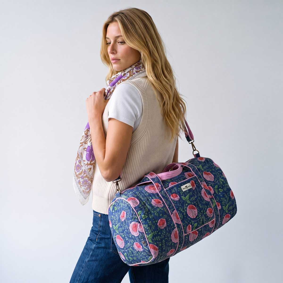 Sac week-end Kusum porté de trois-quarts dos, la main sur la bandoulière, foulard Sandhya au cou
