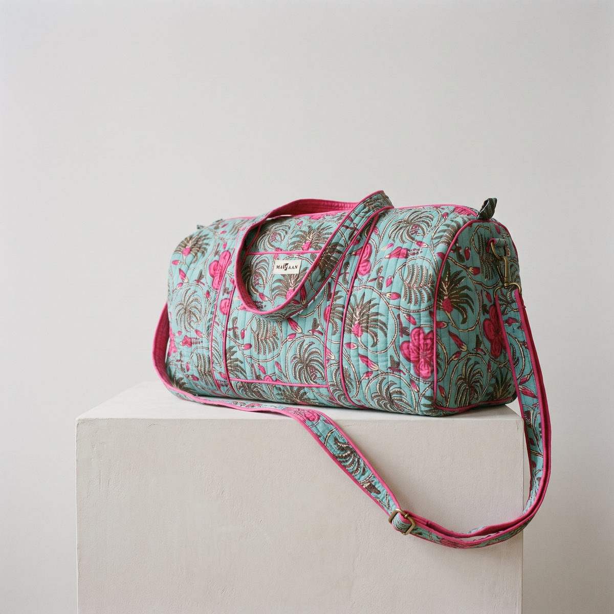 Sac week-end Nilofar : polochon en coton matelassé blockprint, fleurs fuchsia et fougères brun-olive sur turquoise, biais fuchsia