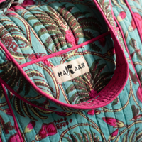 Détail du sac week-end Nilofar : blockprint turquoise et fougères, étiquette MAKAAN sur la poche, biais fuchsia