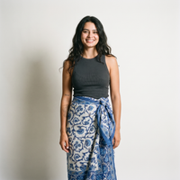 Femme souriante portant le paréo Jamuna noué à la taille, blockprint indigo sur coton crème