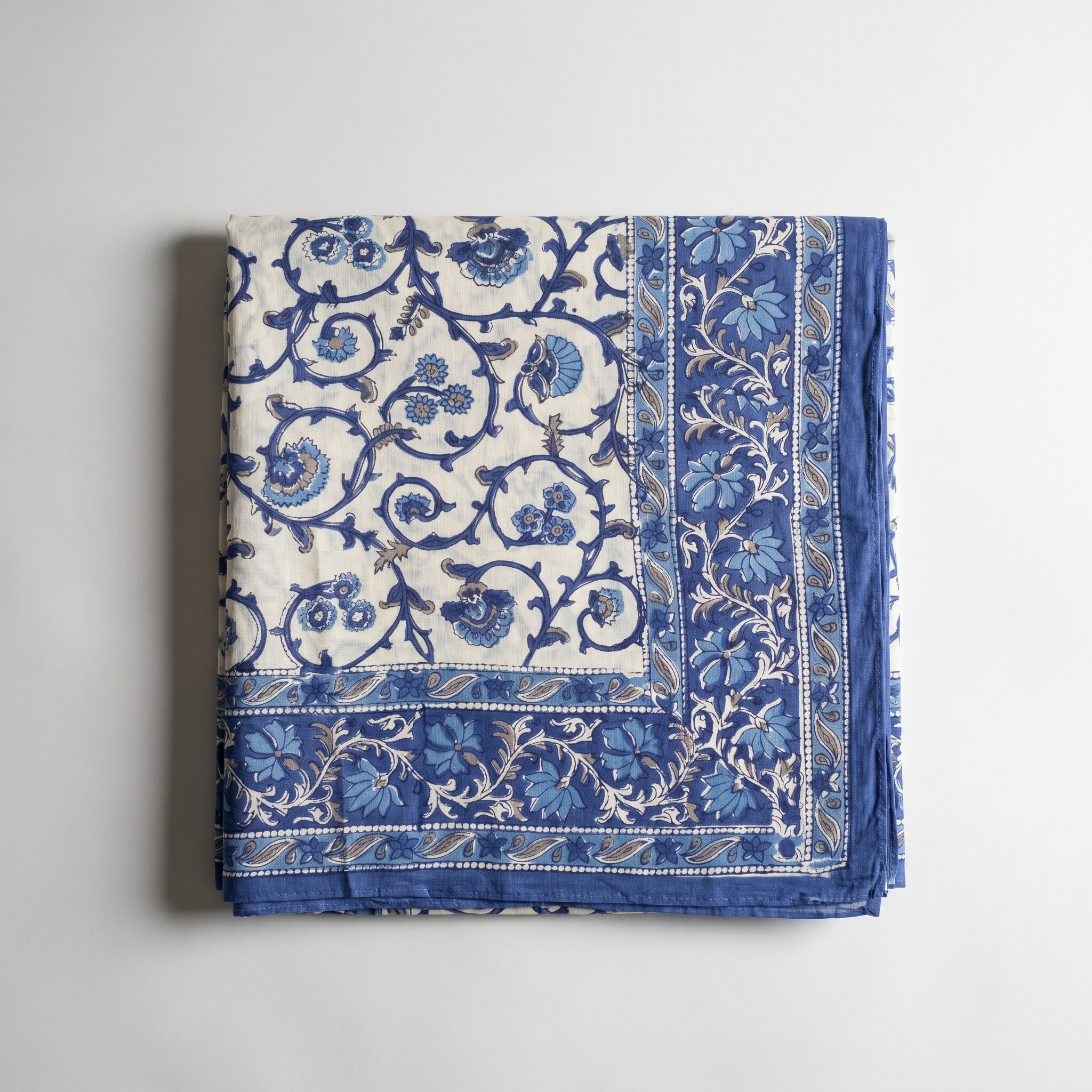 Paréo Jamuna plié à plat : coton blockprint indigo sur crème, large bordure fleurie assemblée en onglet