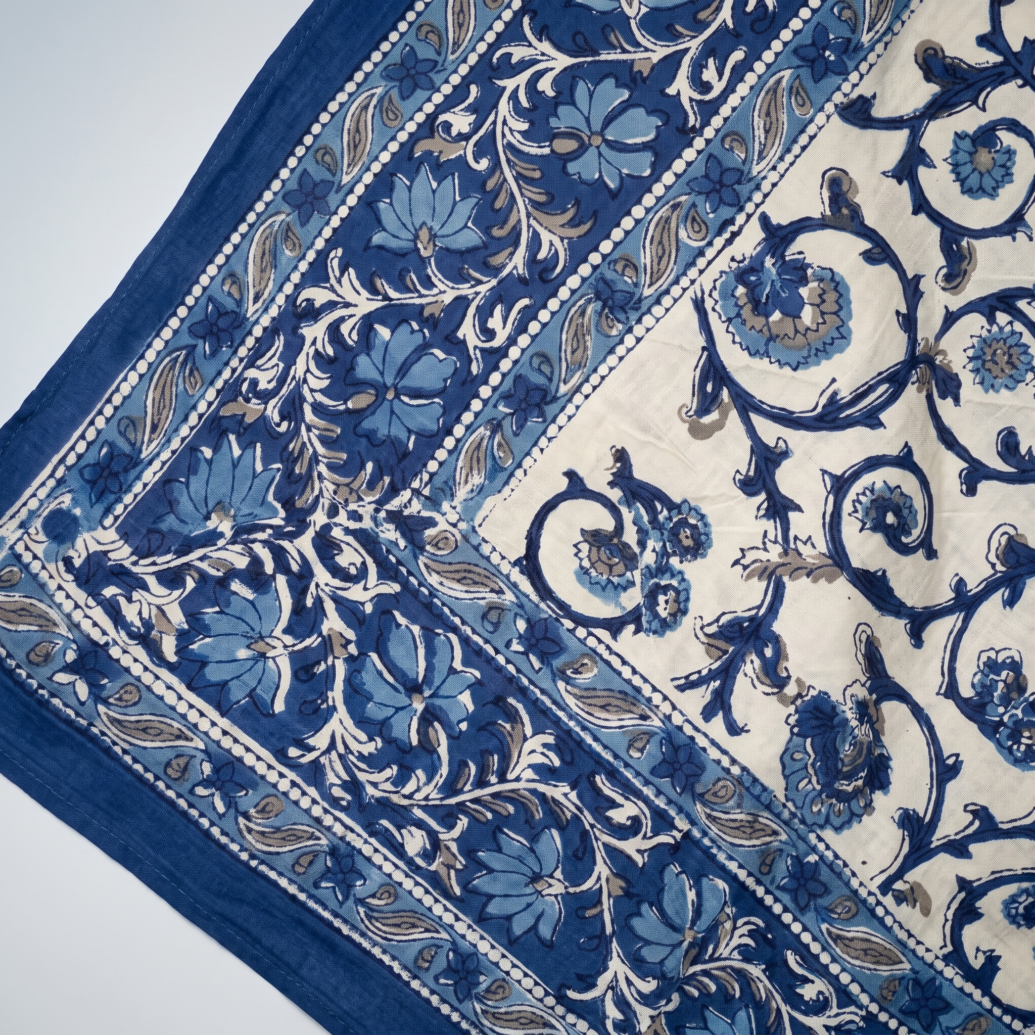 Détail du blockprint du paréo Jamuna : rinceaux indigo, corolles bleu bleuet et filets de perles sur coton crème