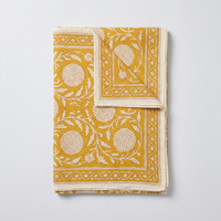 Paréo Haldi plié à plat : coton blockprint, fleurons crème réservés sur jaune curcuma, bordure à dents et liseré écru