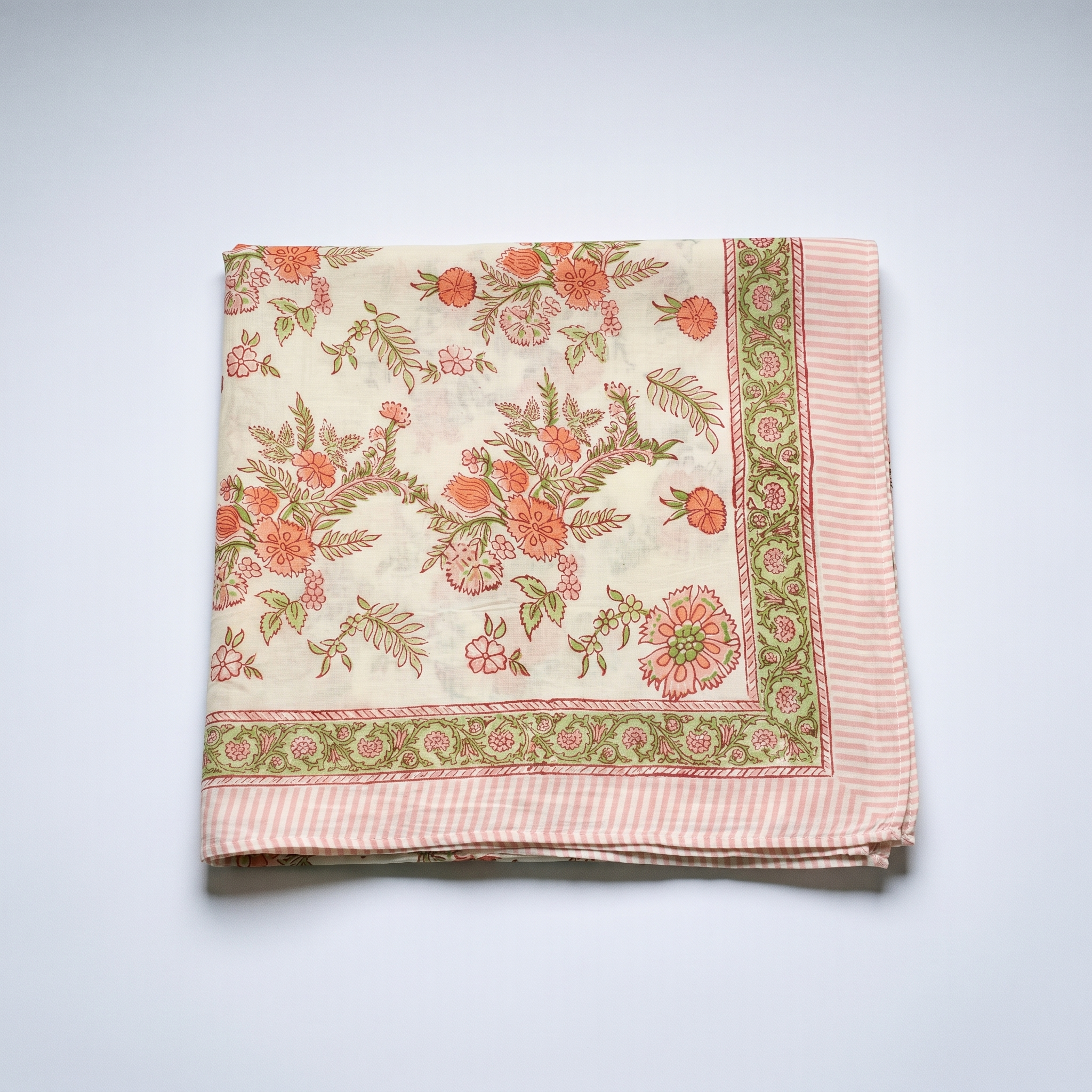 Paréo Champa plié à plat : coton blockprint, corolles corail et fougères vert amande sur crème, bordure rayée rose