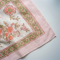 Détail du blockprint du paréo Champa : corolles corail cernées de brique, fougères vert amande et bordure rayée rose