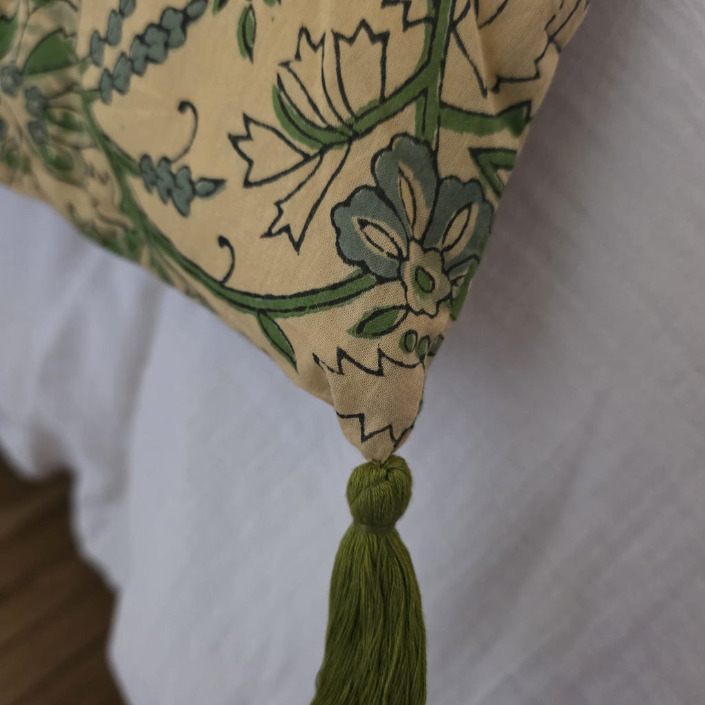 Détail d’un angle de la housse d’édredon Jharna : pompon vert mousse noué sur le coton imprimé