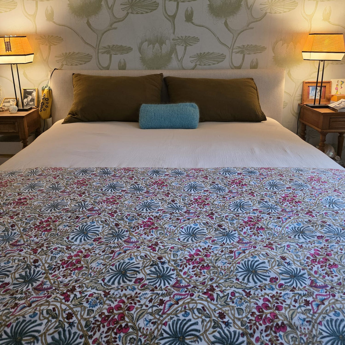 Housse d’édredon Rupali dépliée au pied d’un lit : coton crème imprimé de fleurs roses et de feuillage bleu
