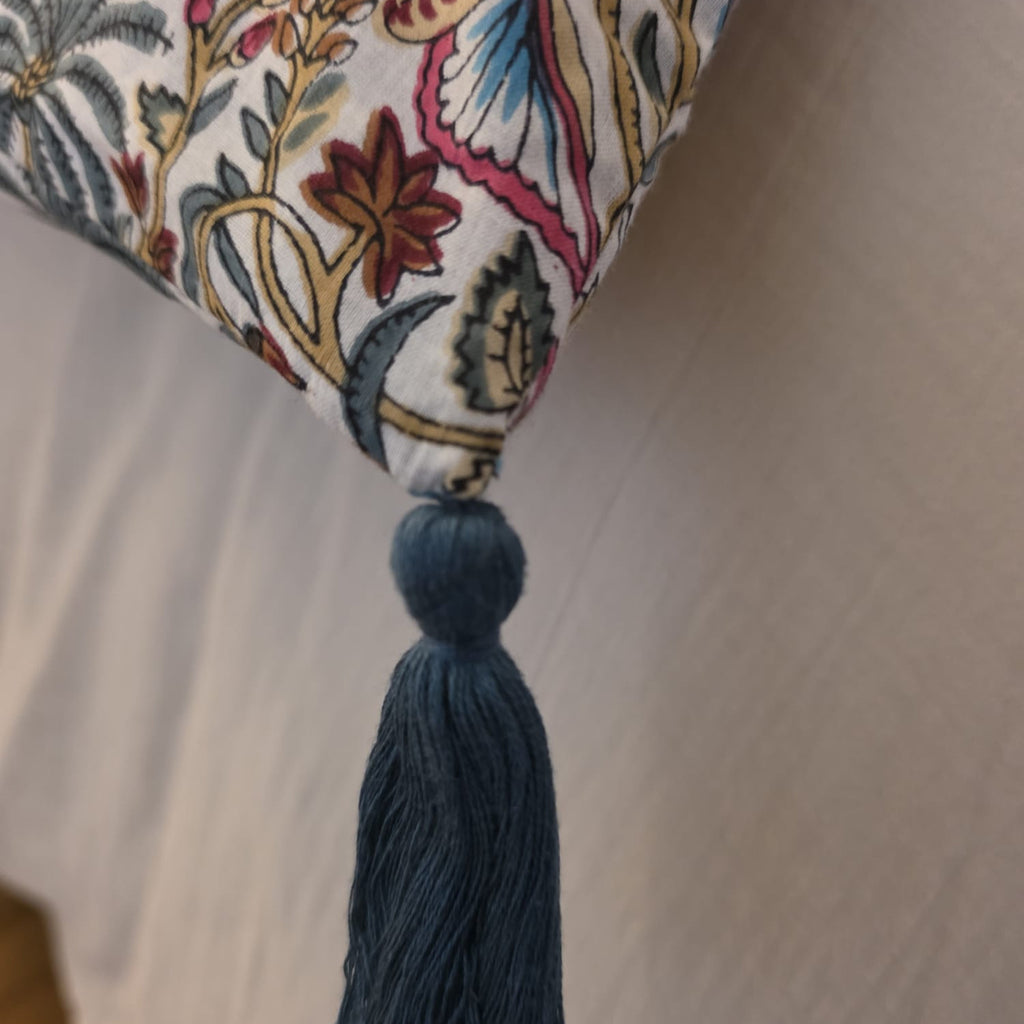 Détail d’un angle de la housse d’édredon Rupali : pompon bleu ardoise noué sur le coton imprimé