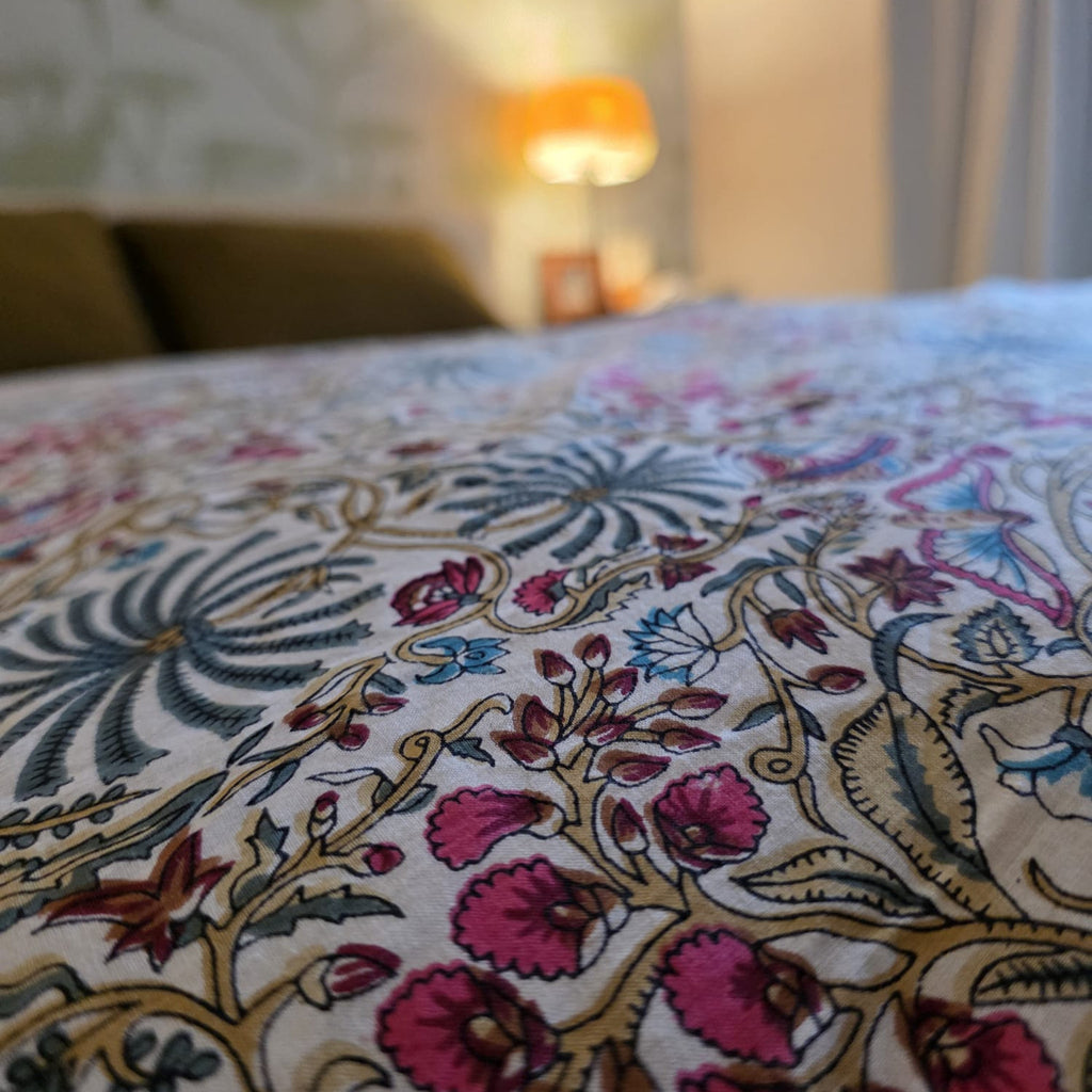 Gros plan du blockprint de la housse Rupali : fleurs roses et palmes bleues sur coton crème