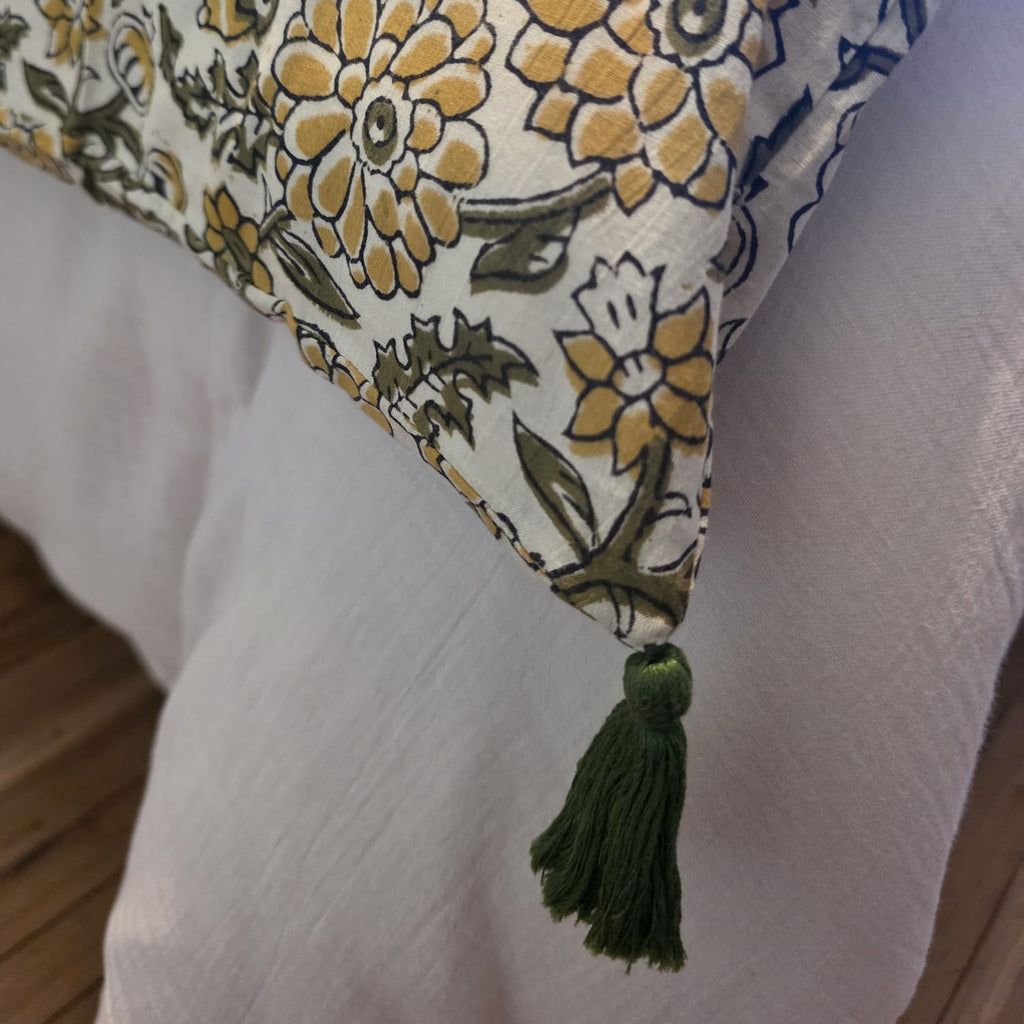 Détail d’un angle de la housse d’édredon Sevanti : pompon vert sapin noué sur le coton imprimé