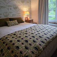Chambre avec la housse d’édredon Sujata dépliée sur le lit, près de la fenêtre