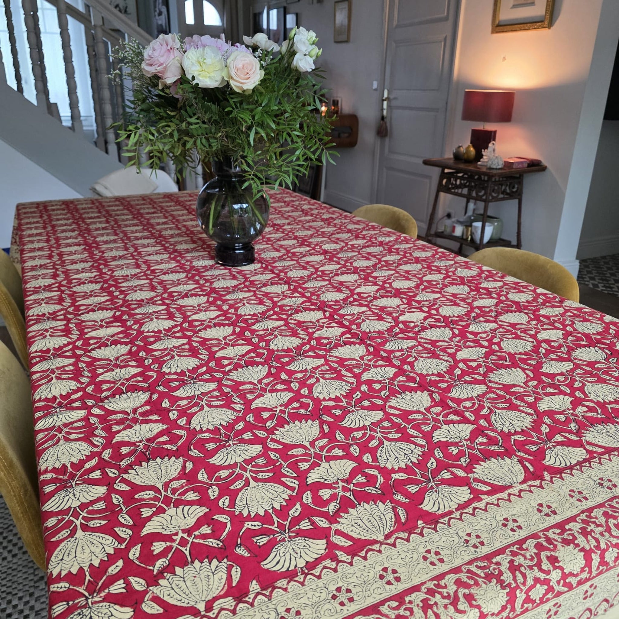 Nappe Arunima dressée sur une table : palmettes et lotus écrus en réserve sur un rouge cramoisi profond
