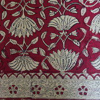 Détail du blockprint de la nappe Arunima : treillis de tiges fines et palmettes écrues sur fond rouge