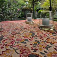 Nappe Chitra sur une grande table de terrasse au jardin, photophores posés au centre