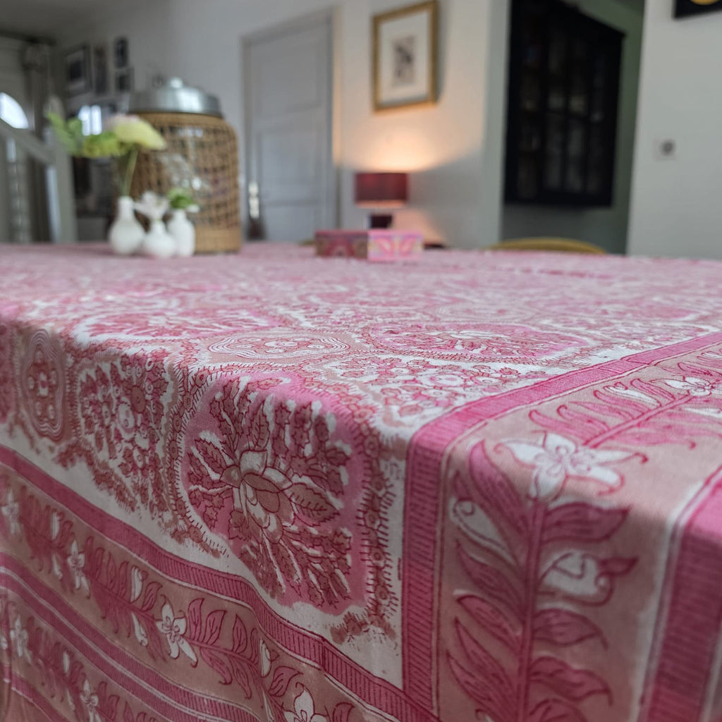 Coin de la nappe Gulabi : la retombée et la bordure rose à guirlande de fleurs blanches