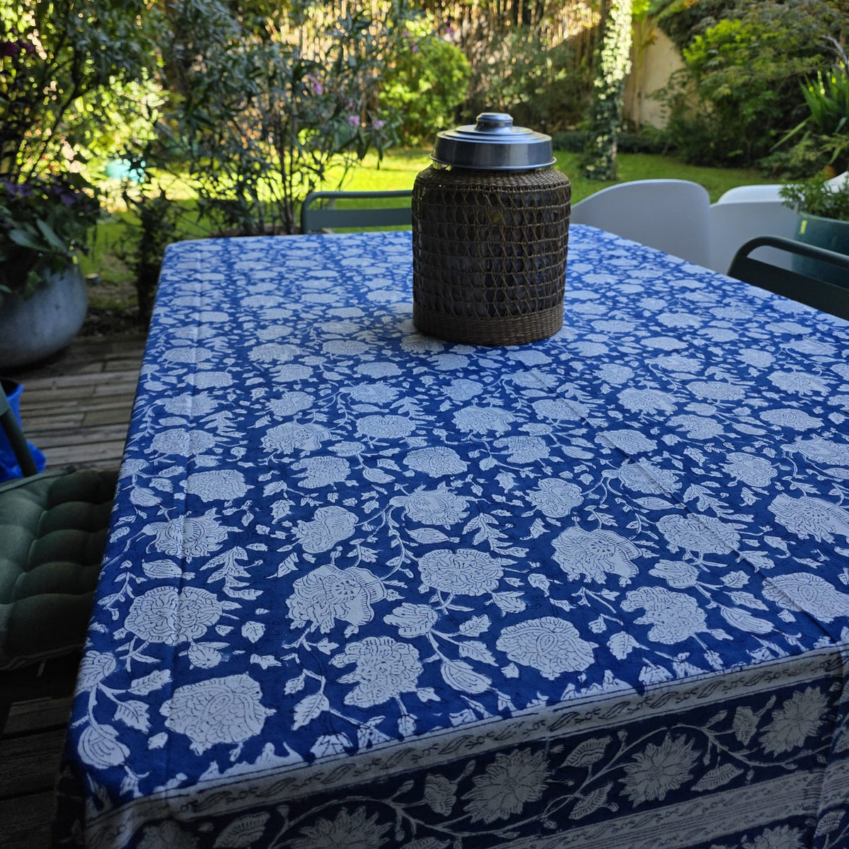 Nappe Kaveri sur une table de terrasse, fleurs blanches réservées sur un fond bleu roi