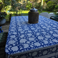 Nappe Kaveri sur une table de terrasse, fleurs blanches réservées sur un fond bleu roi