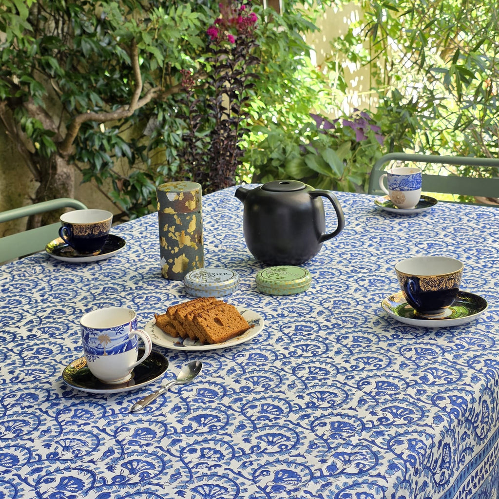 Table ronde habillée de la nappe Lehar en terrasse, bordure imprimée dense visible au premier plan